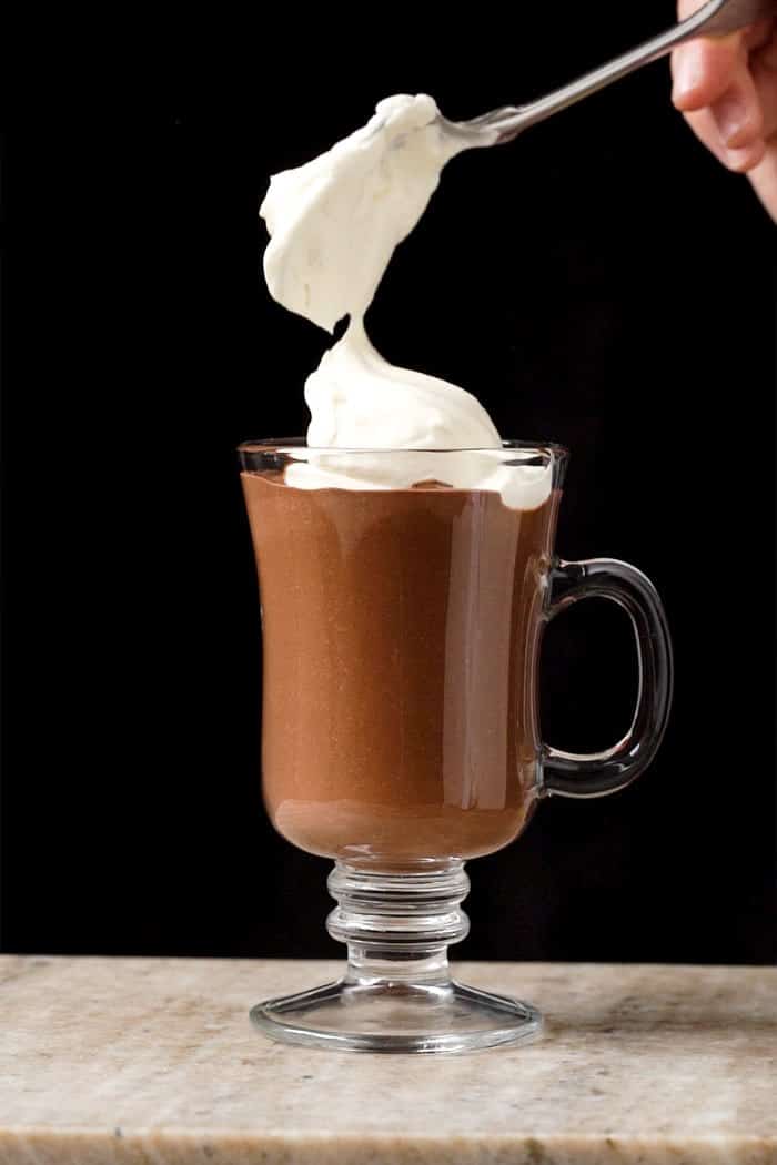 Topping off a keto hot chocolate with whipped cream