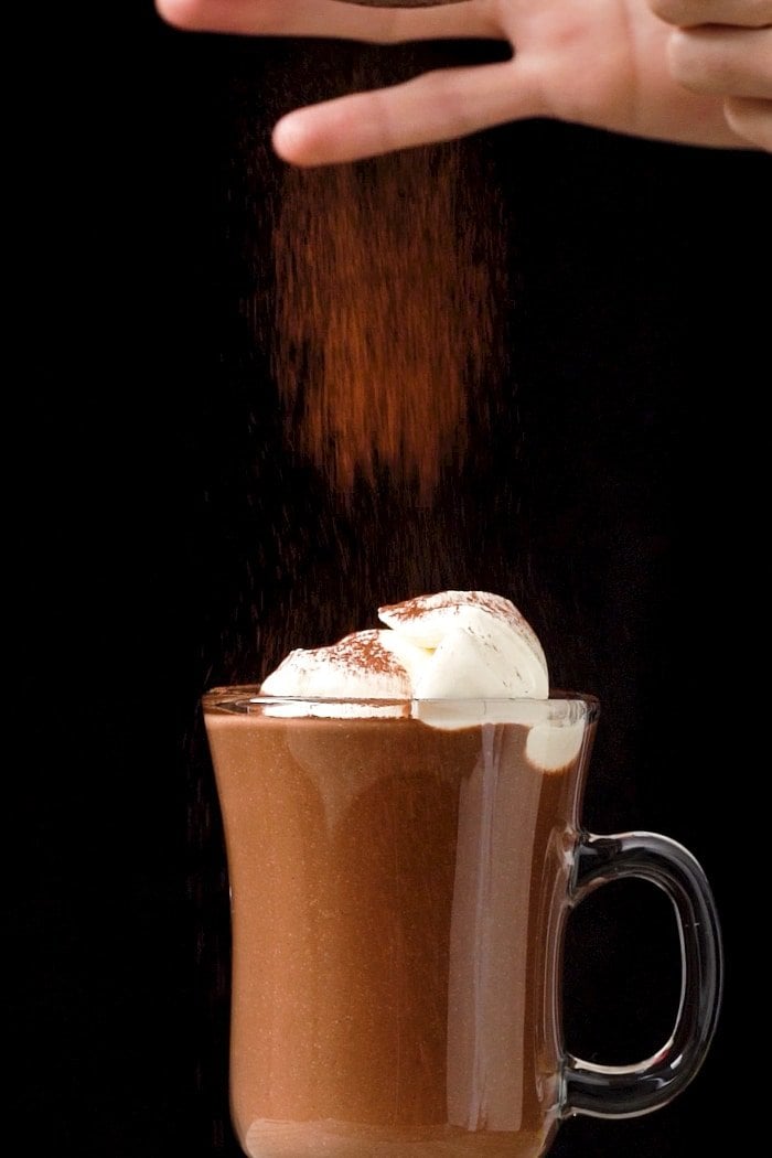Adding a sprinkle of cocoa to a keto hot chocolate