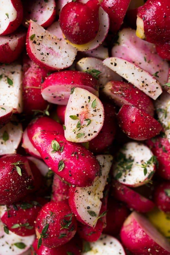 Closeup raw radishes with thyme and black pepper