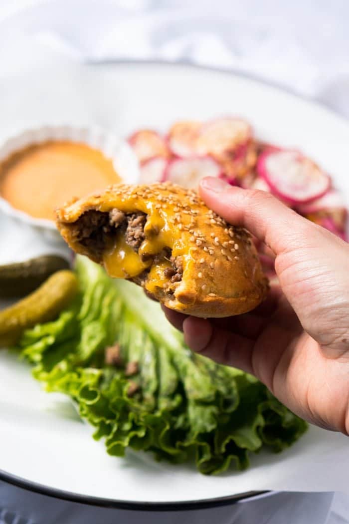 Holding a bitten keto cheeseburger pocket showing the filling