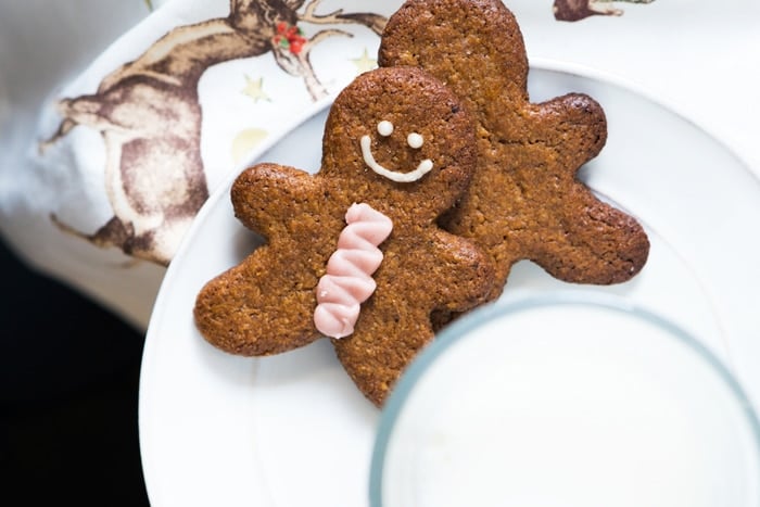 Decorated keto gingerbread men with icing and a glass of milk