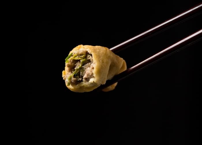 A bitten keto dumpling showing the pork ginger filling