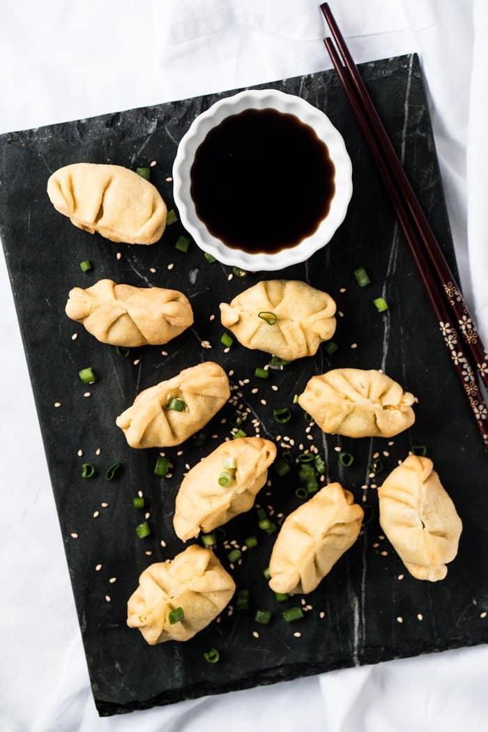 Keto dumplings on a marble serving platter with sauce