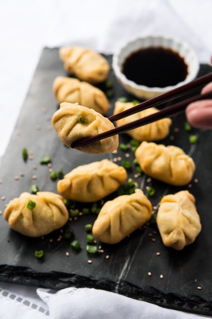 Taking a keto dumpling from the serving platter with chopsticks