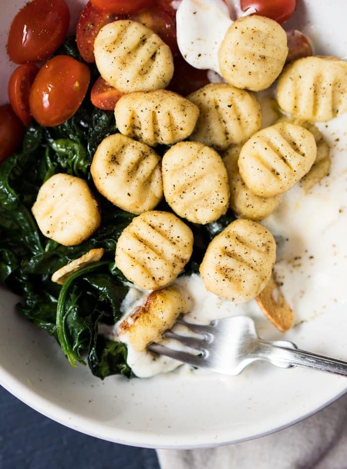 Gluten free & keto ricotta gnocchi with spinach, cherry tomatoes and yogurt sauce