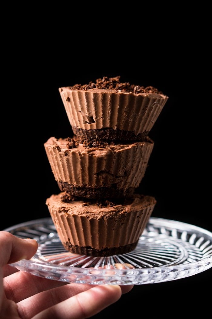 A stack of keto chocolate cheesecake fat bombs on a glass plate