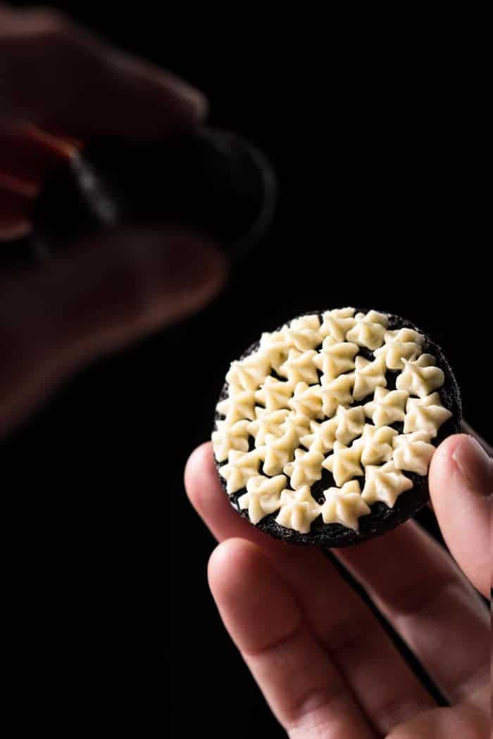 Assembling a keto oreo cookie with vanilla cream filling