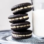Gluten free & keto oreos stacked with a glass of milk