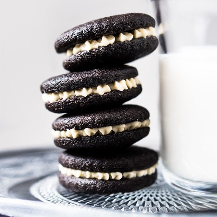 Gluten free & keto oreos stacked with a glass of milk