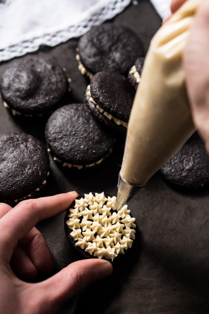 Piping on the vanilla cream filling of the oreo cookies