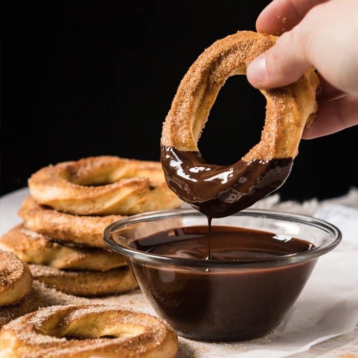 Dipping a keto churro donut in chocolate sauce