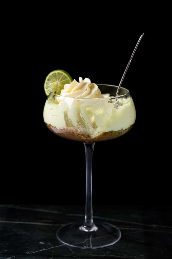 Keto key lime cheesecake with a spoon and a black background
