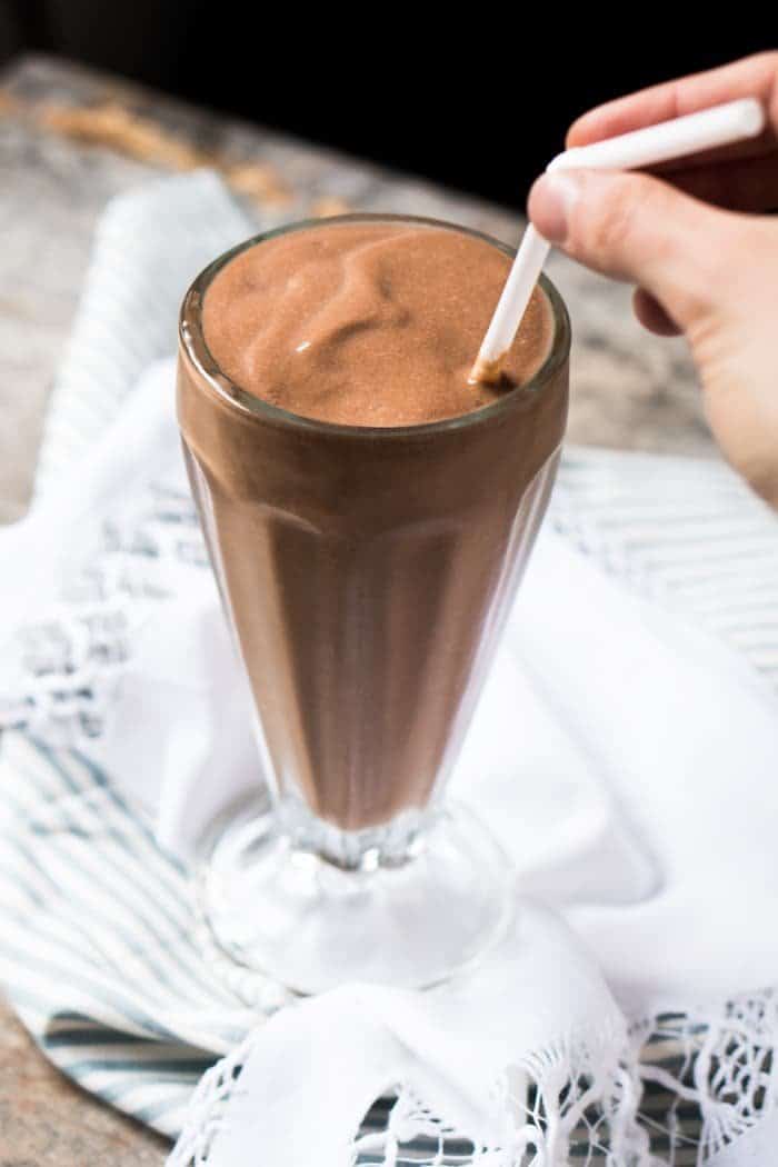 Drinking a keto chocolate milkshake with a straw