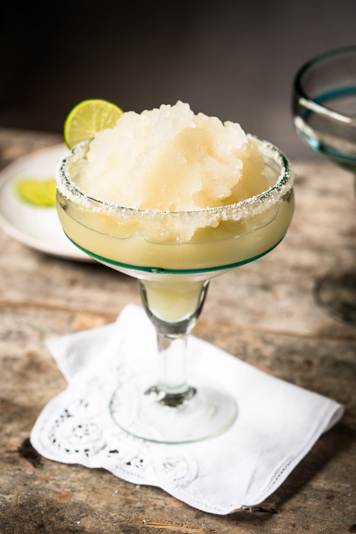 Frozen keto margarita in a tall glass with a lime wedge