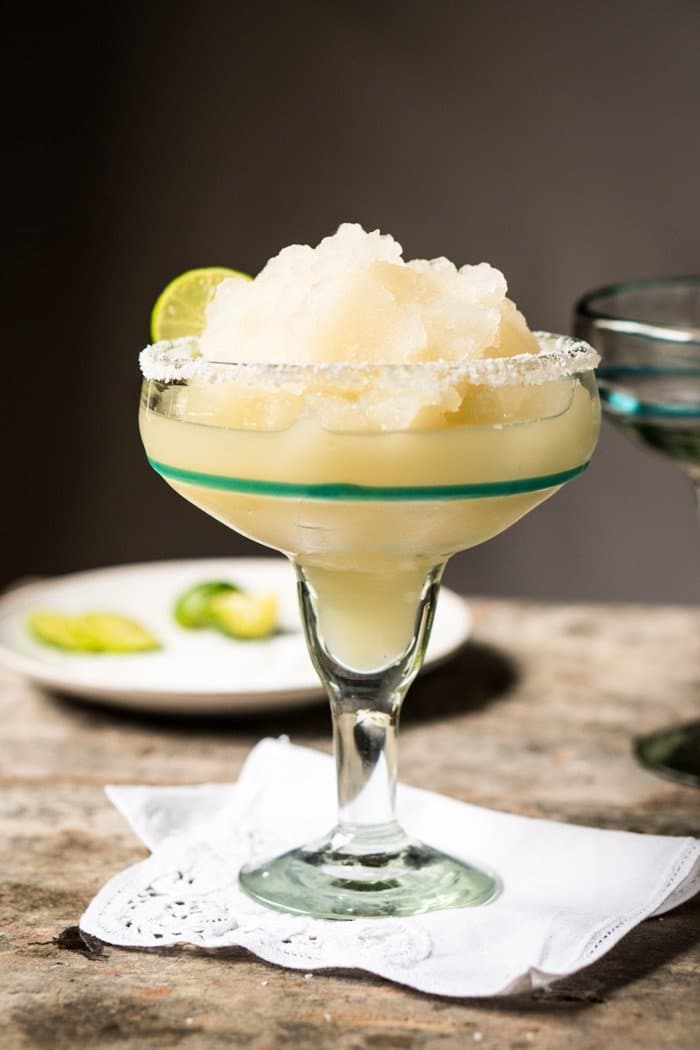 Frozen keto margarita in a tall glass with a lime wedge