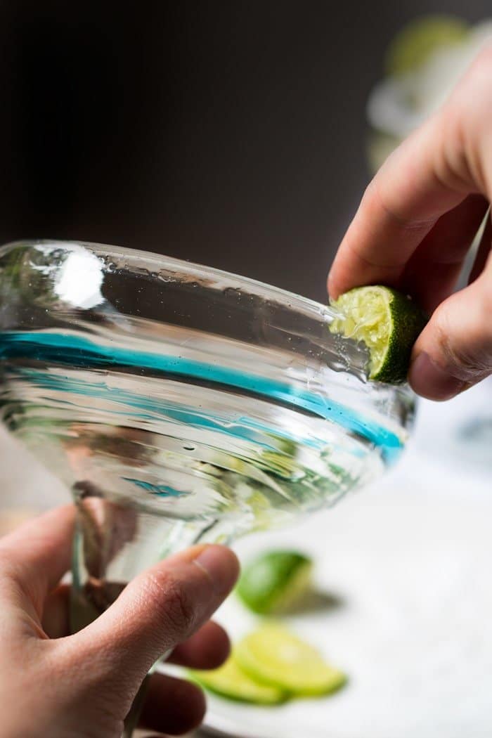 Running a lime through the rim of a margarita glass