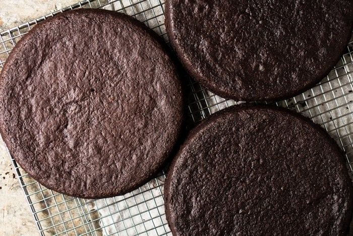 Three layers of paleo & keto chocolate cake on a wire rack