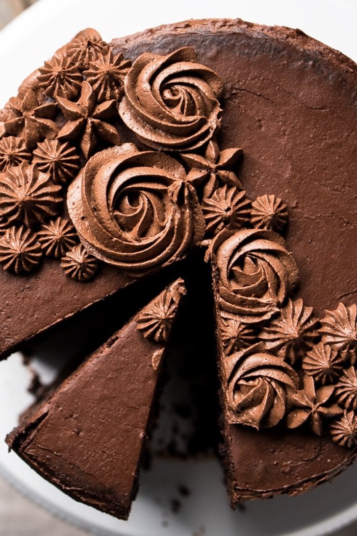 Overhead shot of sliced keto chocolate cake with flower buttercream frosting details