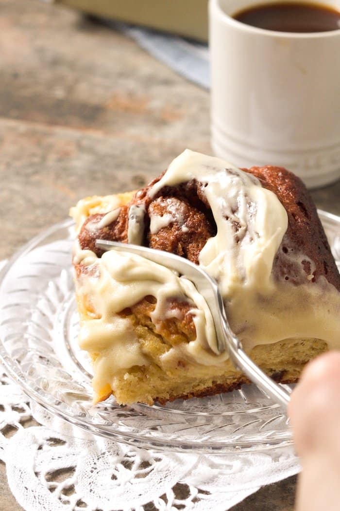 Cutting a fluffy Keto cinnamon roll with a fork