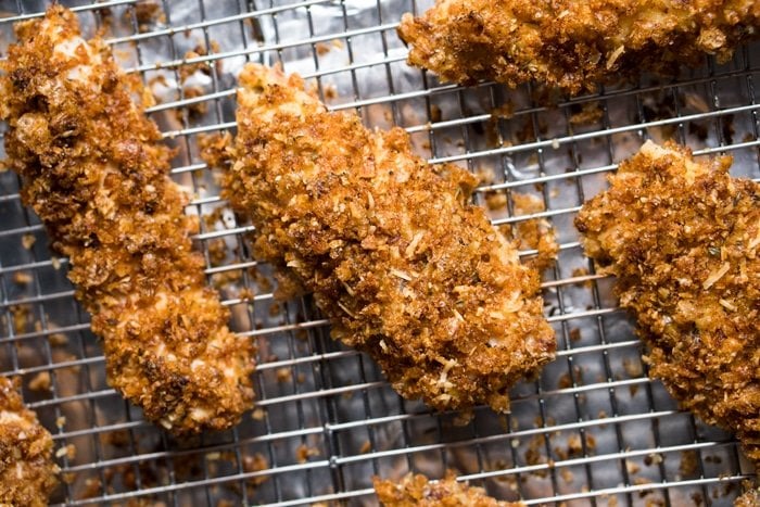 Freshly coated unbaked keto chicken tender on a rack