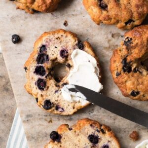 A Keto Blueberry bagel, sliced in half with a smear of cream cheese