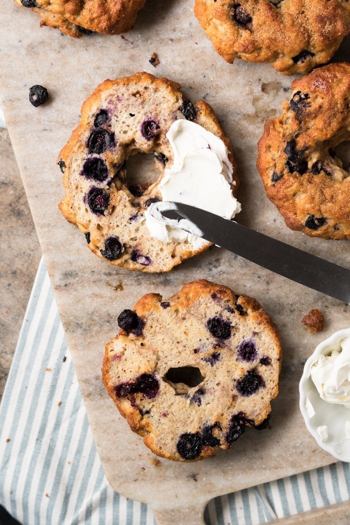 A Keto Blueberry bagel, sliced in half with a smear of cream cheese