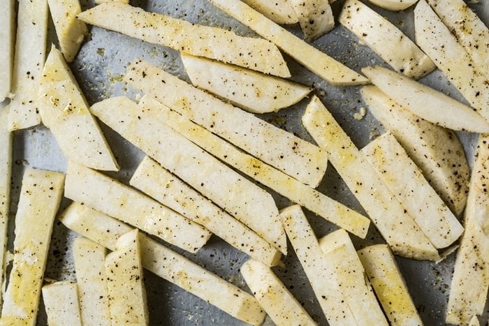 Unbaked sliced jicama on a baking tray
