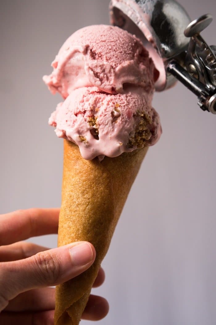 A keto ice cream cone with two scoops of strawberry ice cream