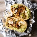 A keto beef burrito cut in half, wrapped in foil
