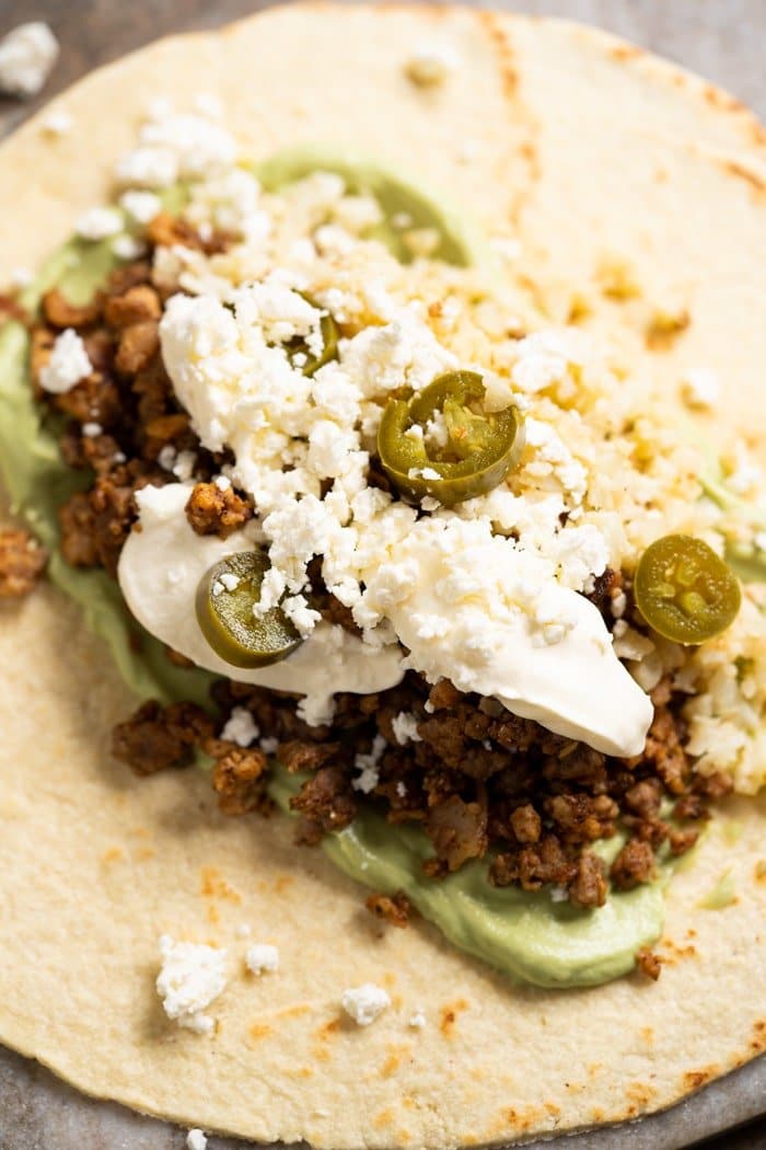 A keto tortilla with beef burrito fillings piled on top