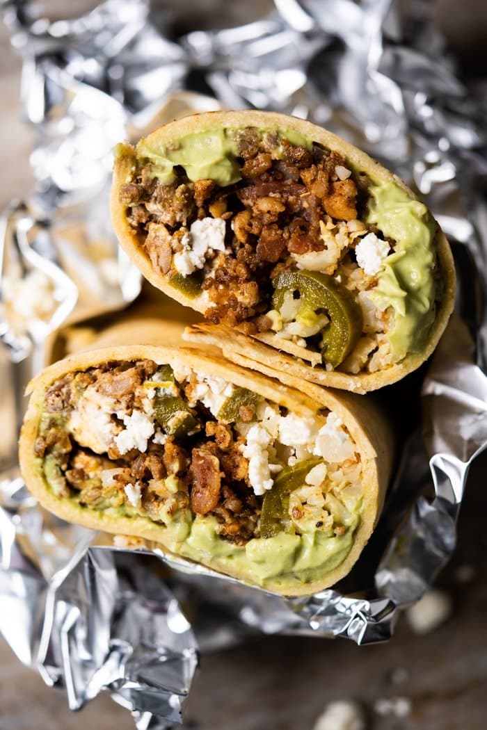 Closeup of a keto beef burrito cut in half, wrapped in foil