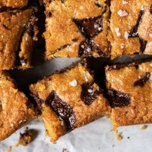 Sliced keto peanut butter blondies with chocolate chunks and flakey sea salt
