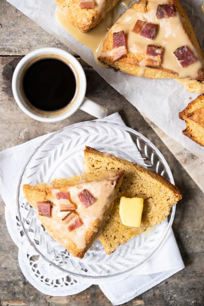 Sliced keto maple bacon scone with a pad of butter and a shot of espresso