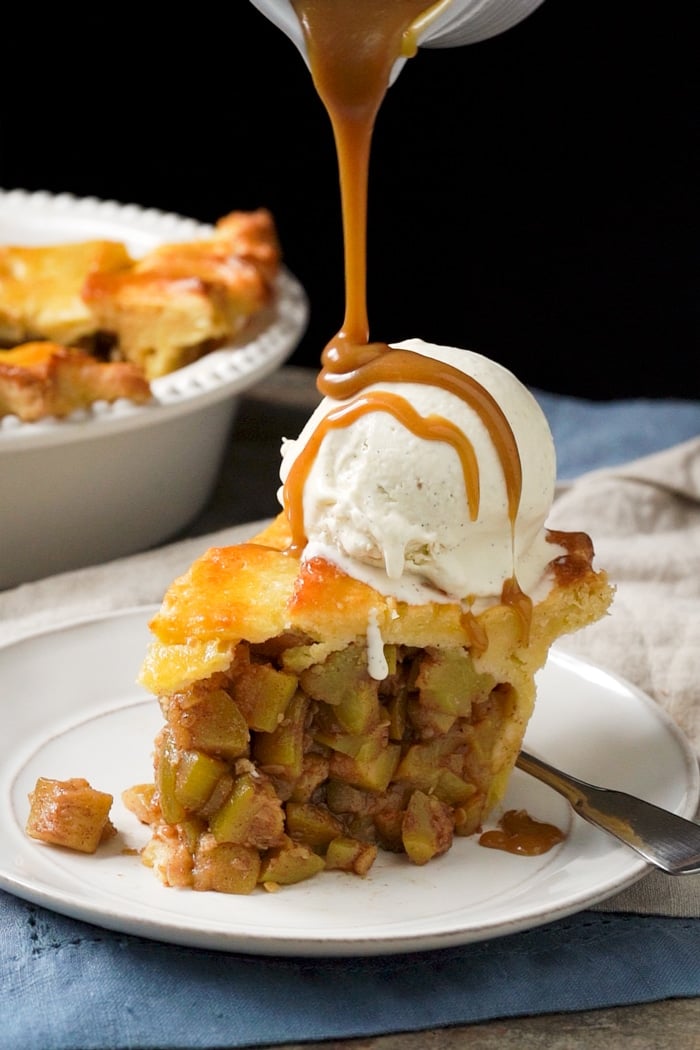 A slice of keto apple pie with a scoop of vanilla ice cream and caramel sauce