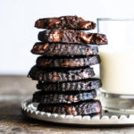 Piled up keto chocolate shortbread cookies with a glass of milk
