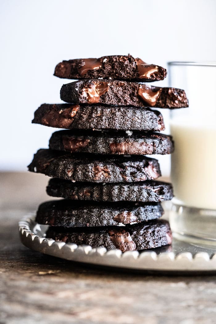 Piled up keto chocolate shortbread cookies with a glass of milk