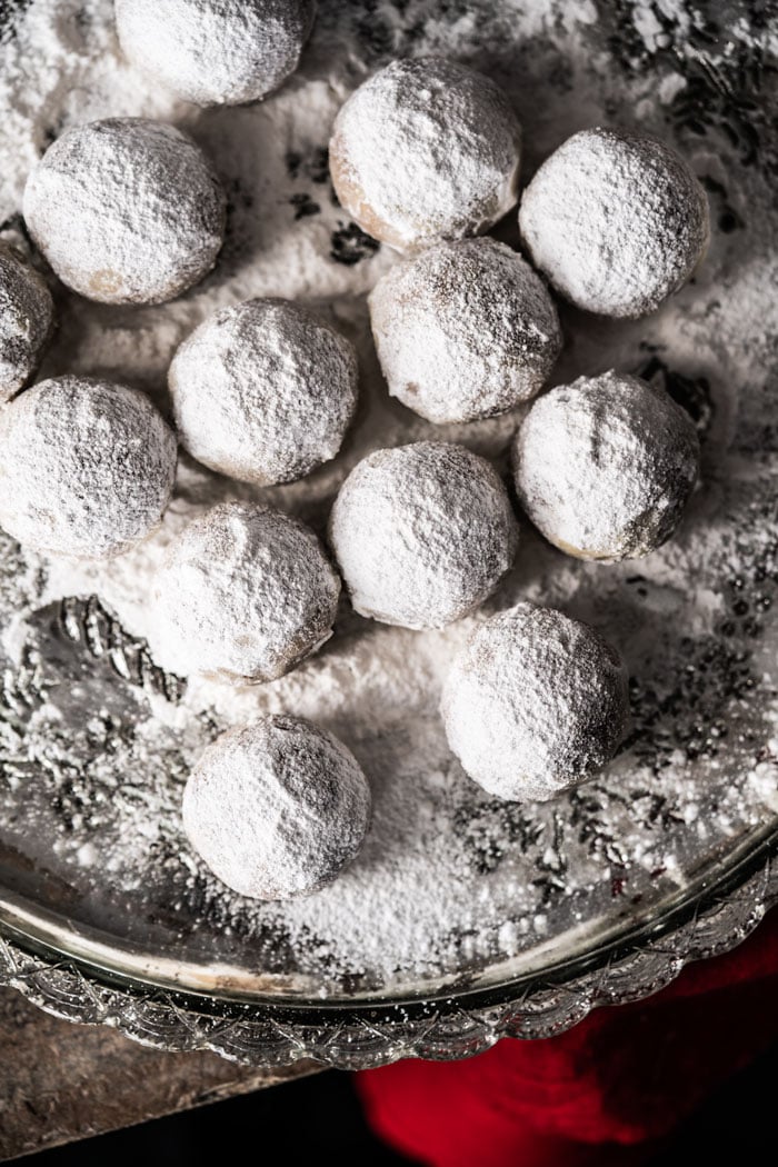 Rolling keto snowball cookies in powdered sweetener