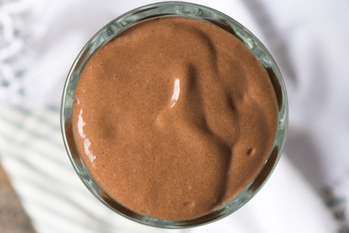Overhead shot of a creamy keto milkshake with chocolate and avocado