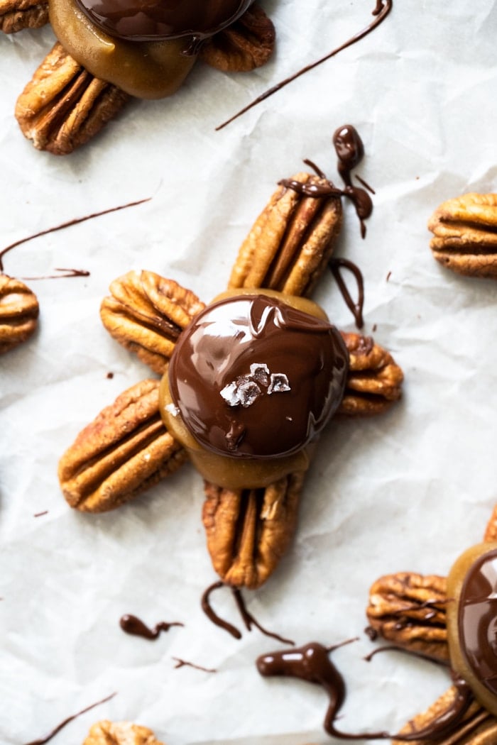 Drizzling melted chocolate on a keto turtle