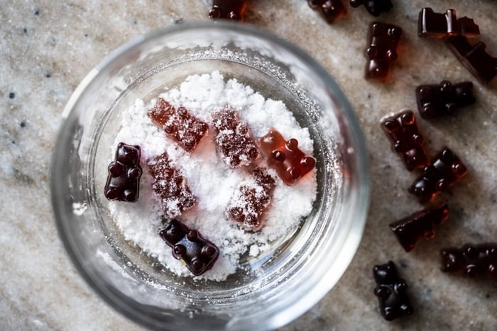 Dipping keto gummy bears into sour coating