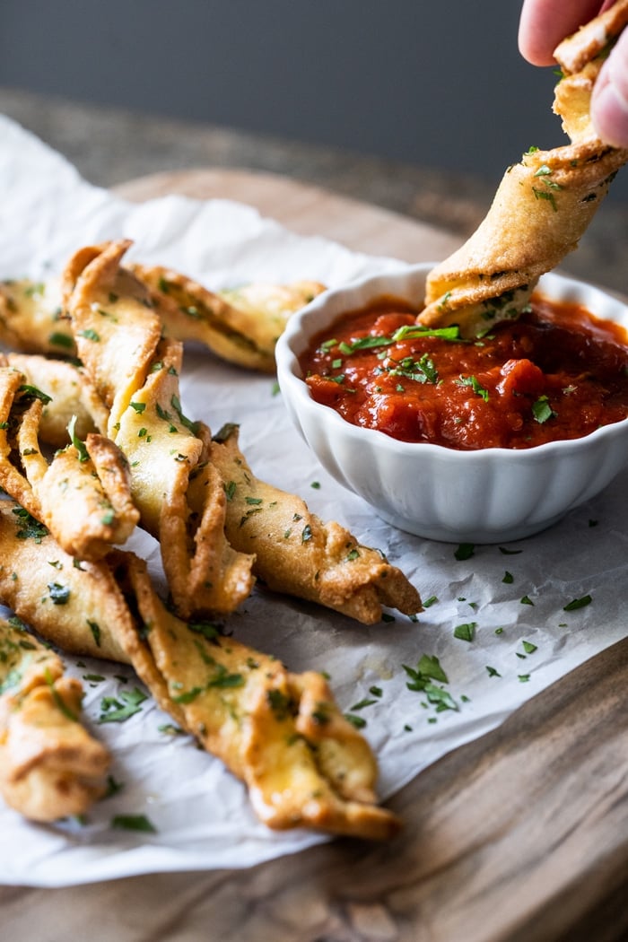 Dipping a keto garlic breadstick in marinara sauce