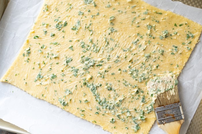 Brushing the Keto Dough with garlic butter and parsley