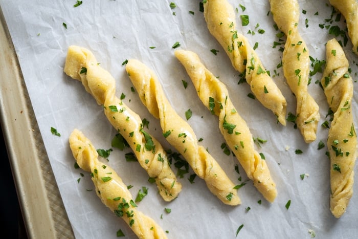 Unbaked keto breadsticks with fresh parsley