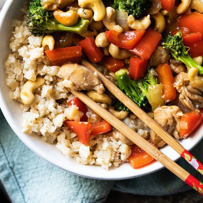 Paleo & keto cashew chicken with cauliflower rice and chopsticks