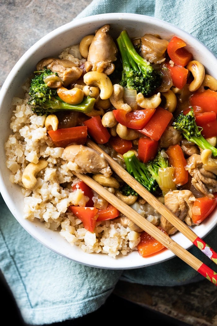 Paleo & keto cashew chicken with cauliflower rice and chopsticks