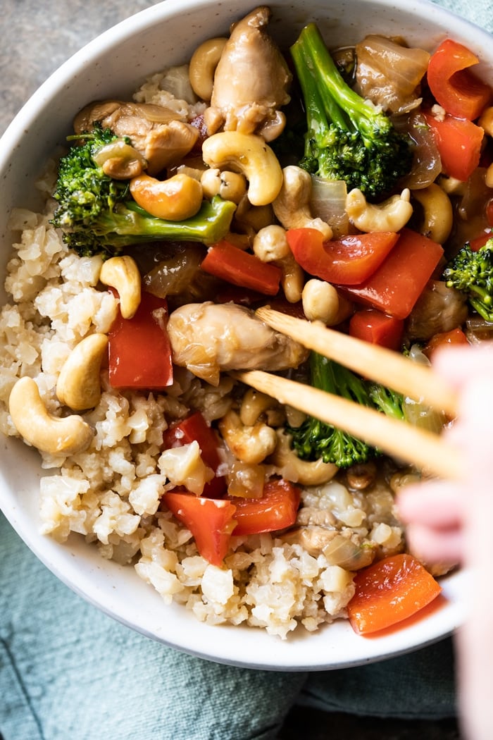 Eating paleo cashew chicken with chopsticks