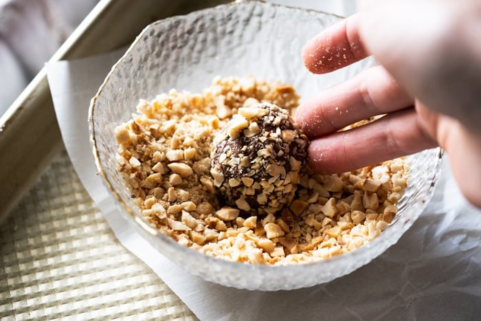 Rolling Nutella truffles in chopped hazelnuts