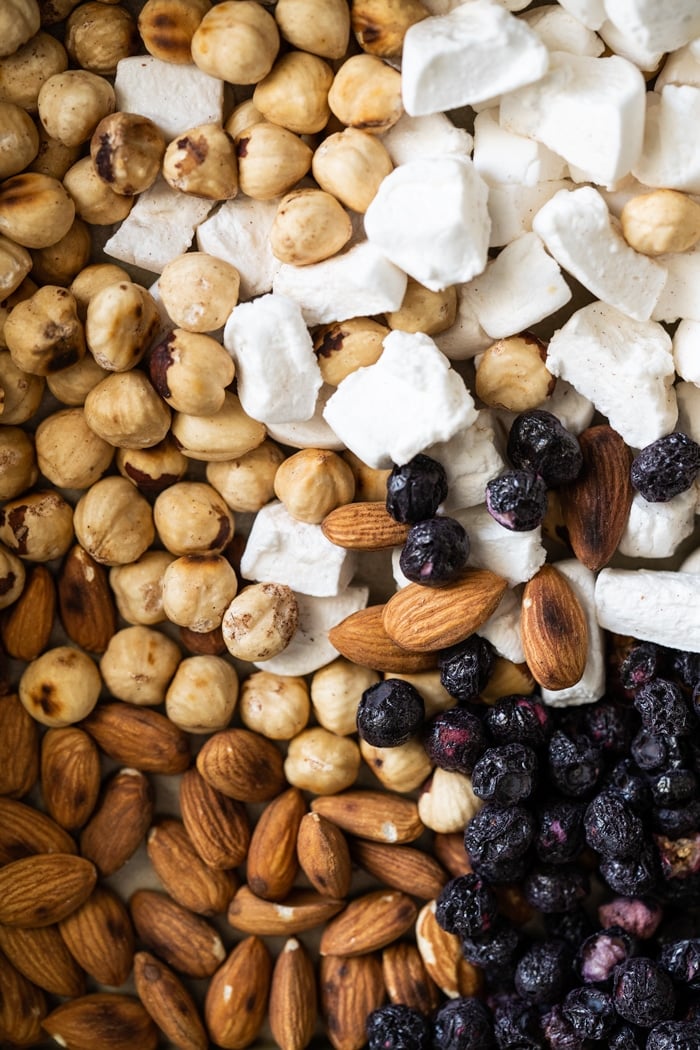 Closeup keto marshmallows, hazelnuts, almonds and dried blueberries for low carb rocky road
