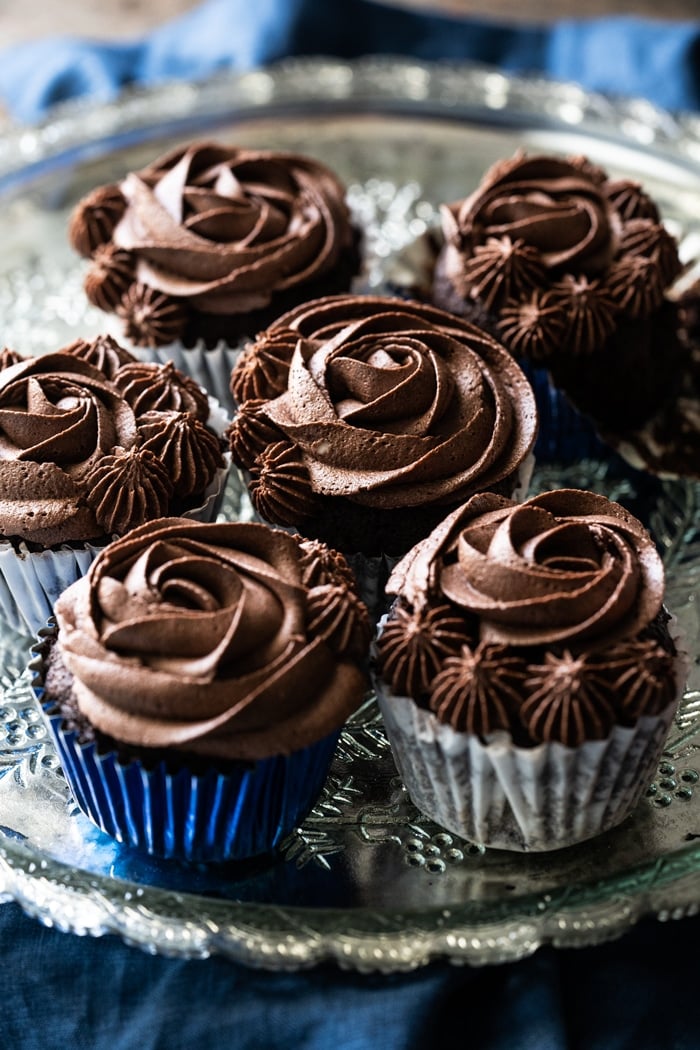 Keto chocolate cupcakes with buttercream frosting on a silver platter
