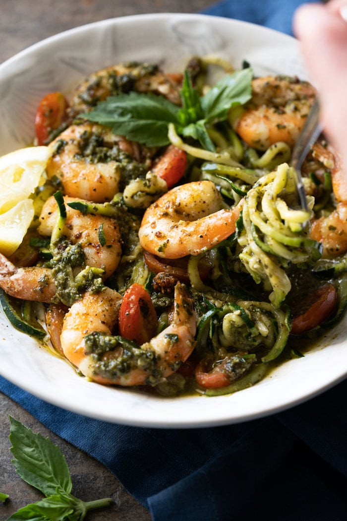 Eating keto shrimp zoodles with a fork